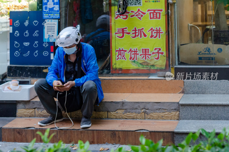 在门口坐着等待取餐的骑手