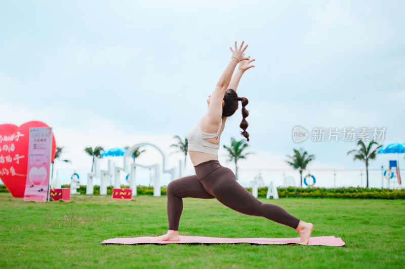 在户外绿色的草地上做瑜伽的亚洲女人