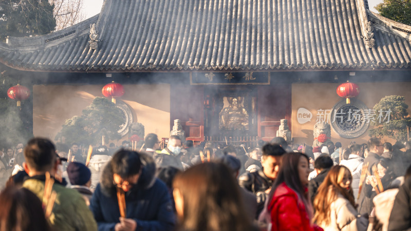 古寺庙前众人手持香火烟雾缭绕