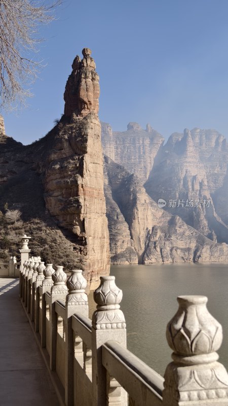 水边石制护栏旁的壮丽山峰景致