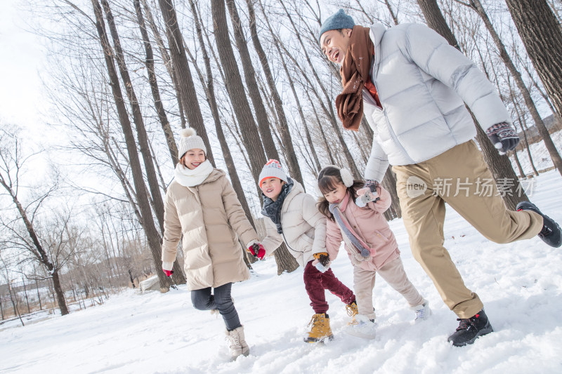 欢乐家庭在雪地里奔跑