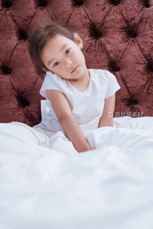 穿着白色衣服坐在床上的中国女孩