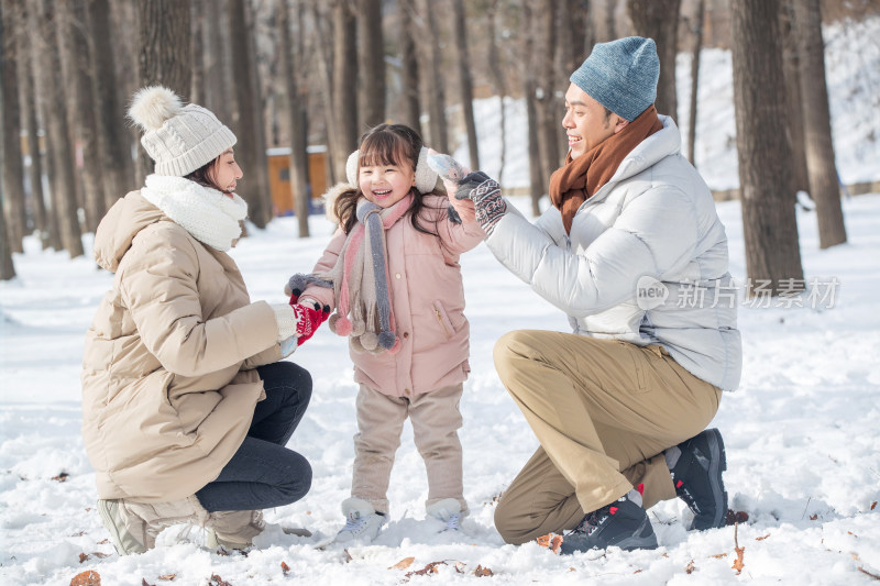 一家三口在雪地里玩耍