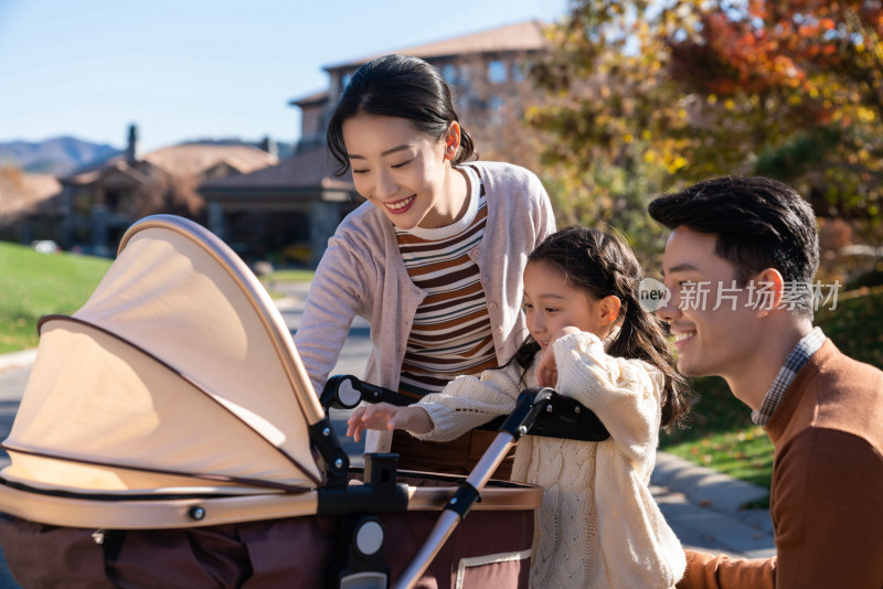 年轻夫妻推着婴儿车散步