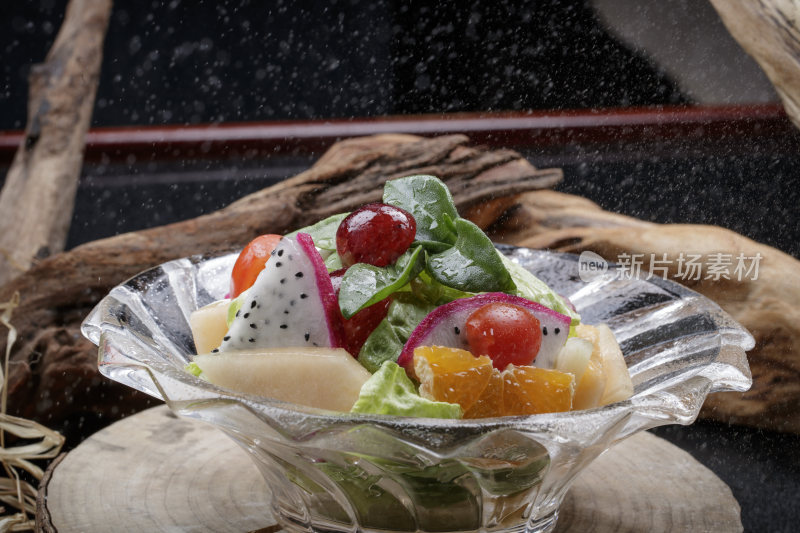花纹玻璃碗装的果蔬拌菜摆放在樟木砧板上