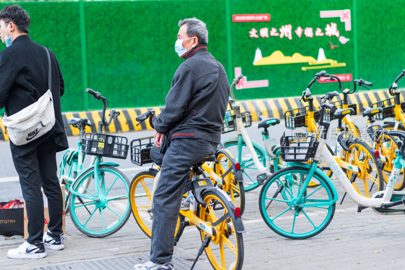 男子街头骑共享单车场景