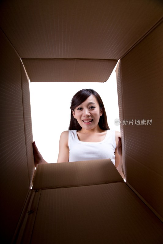 棚拍年轻女人打开纸箱