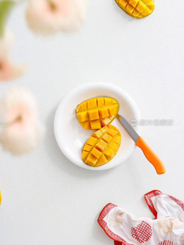 白色桌面上摆放着的切开的新鲜水果芒果