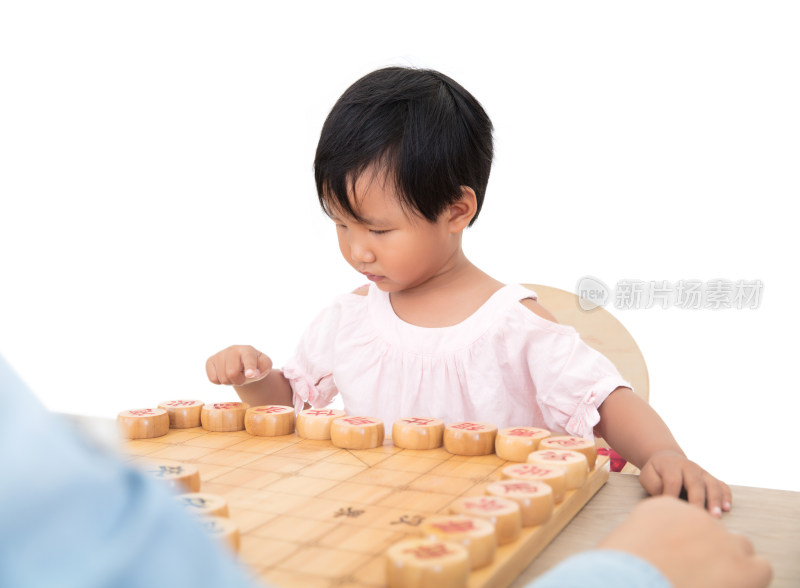 黄皮肤小女孩在认真的和大人下中国象棋