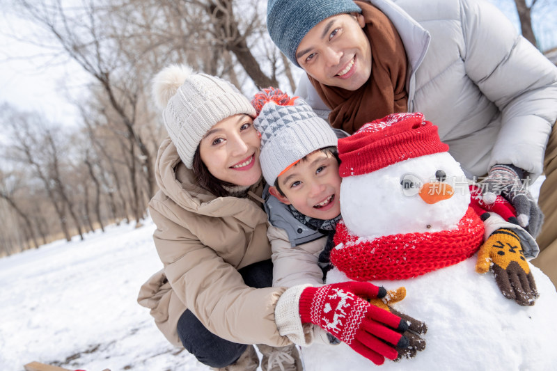 一家三口在雪地里堆雪人