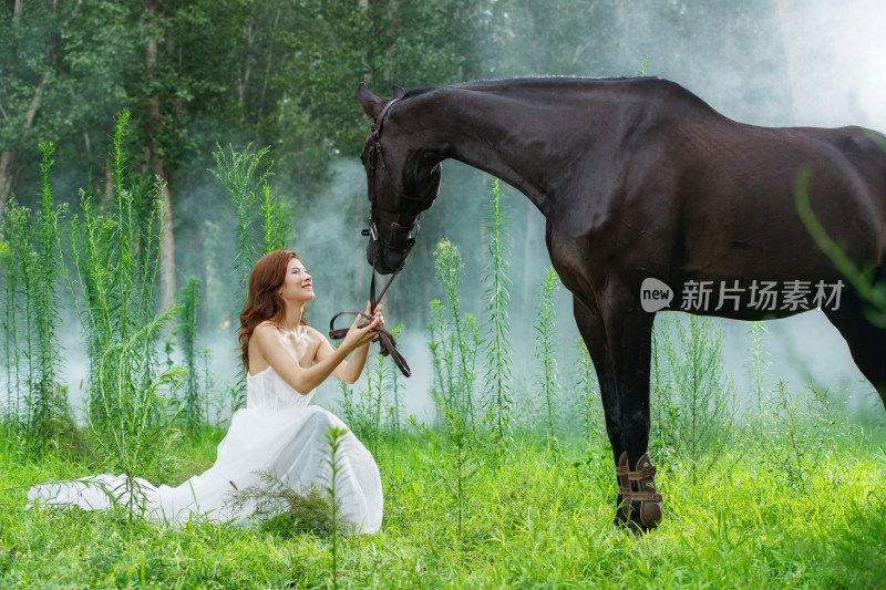 穿婚纱的漂亮青年女人牵着马