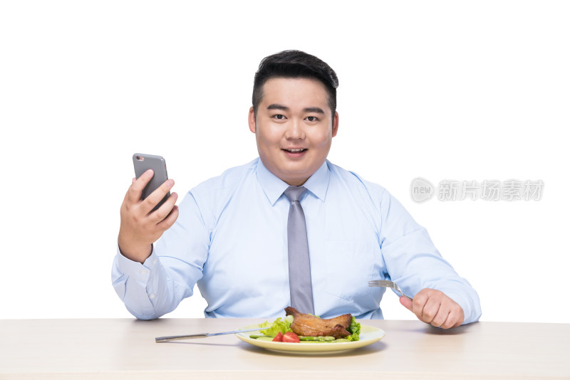 胖子在拿着手机吃饭