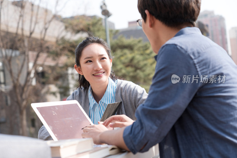 大学生情侣在校园里学习