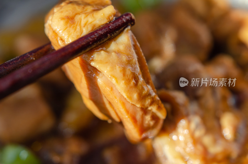 阳光下，用筷子夹起一块鸡肉肉块