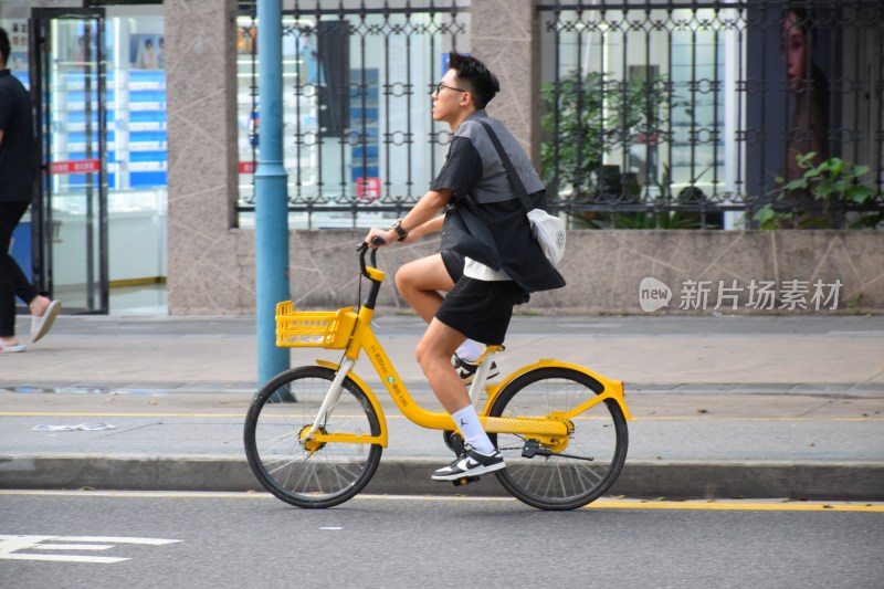 男子骑行黄色共享单车