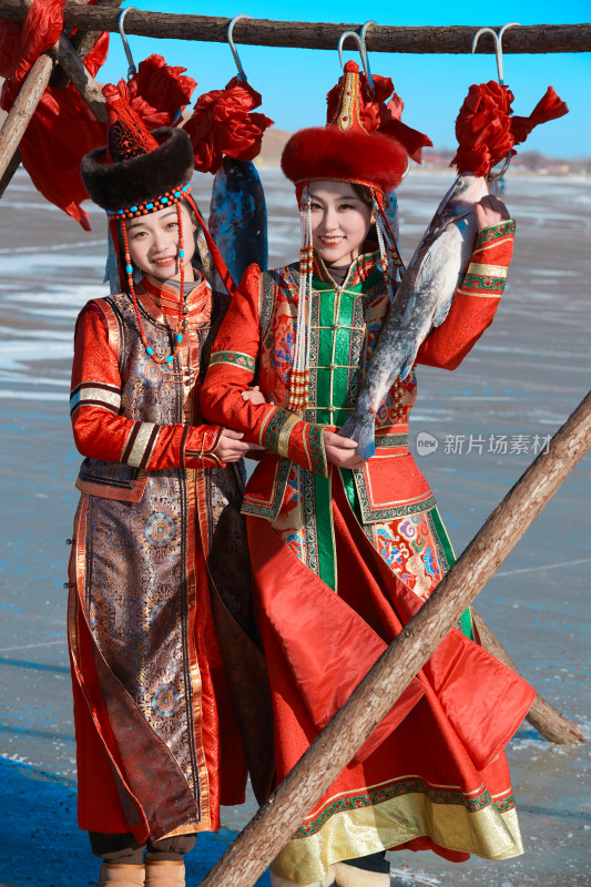 穿着蒙族服饰参加冬季捕鱼活动的闺蜜少女