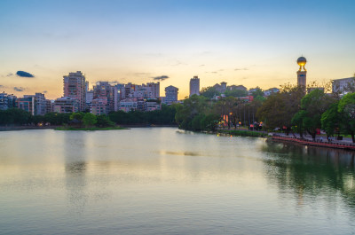 夕阳中福建省福州西湖公园的水边城市建筑