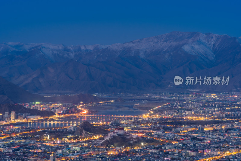 夜幕下的城市与雪山