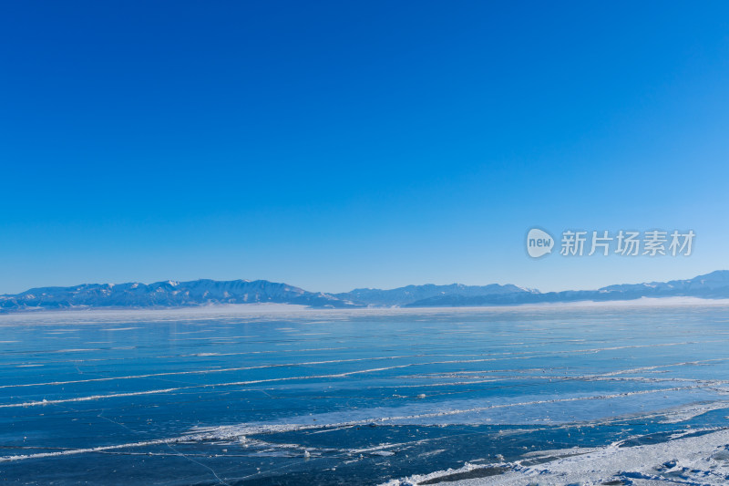 新疆冬季赛里木湖雪景雪山冰湖蓝冰日照金山