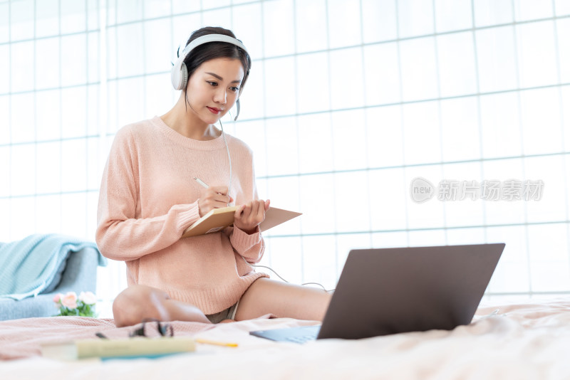 年轻女子在床上使用电脑