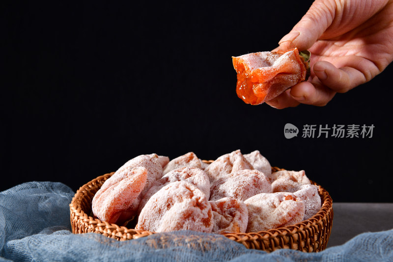 篮子里放着一些表面带霜的柿饼，富平柿饼