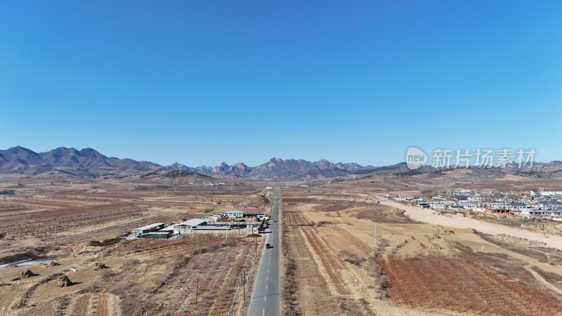 空旷原野中的道路与远山村庄景致