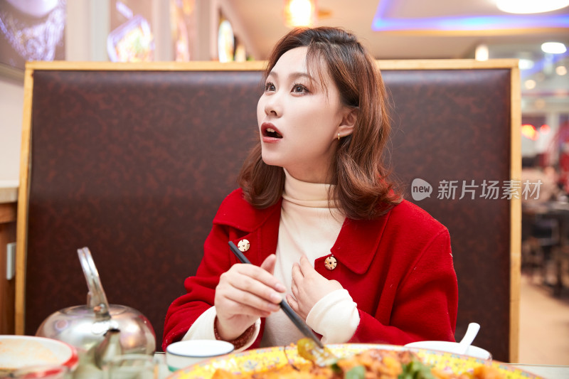 在餐厅吃美味新疆大盘鸡的亚洲少女