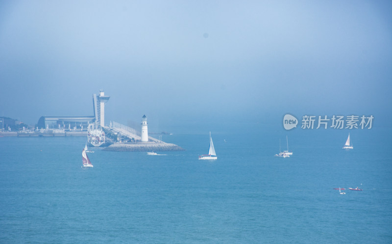 山东青岛大海上的灯塔和航行的帆船
