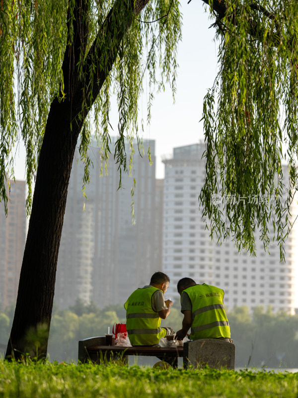 清晨公园里 吃早餐的建筑工人背影