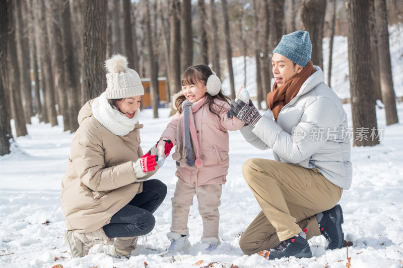 一家三口在雪地里玩耍