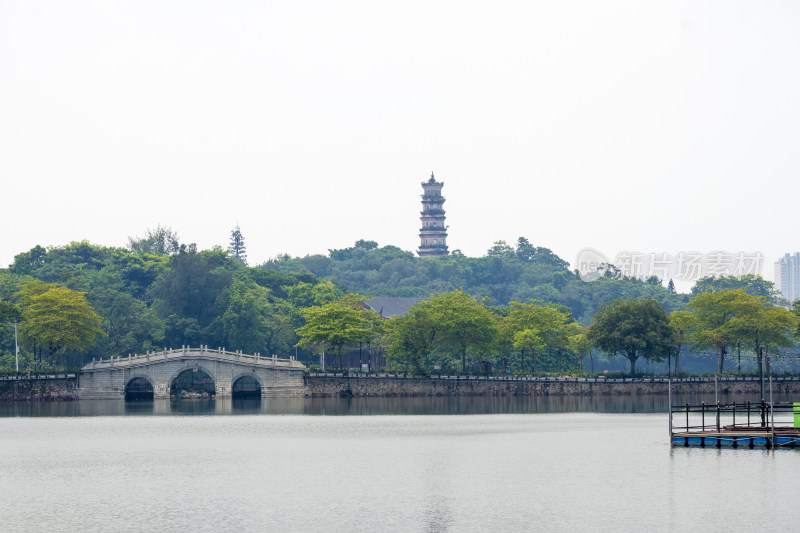 晴朗天空下湖面上的三孔桥和中式古塔建筑