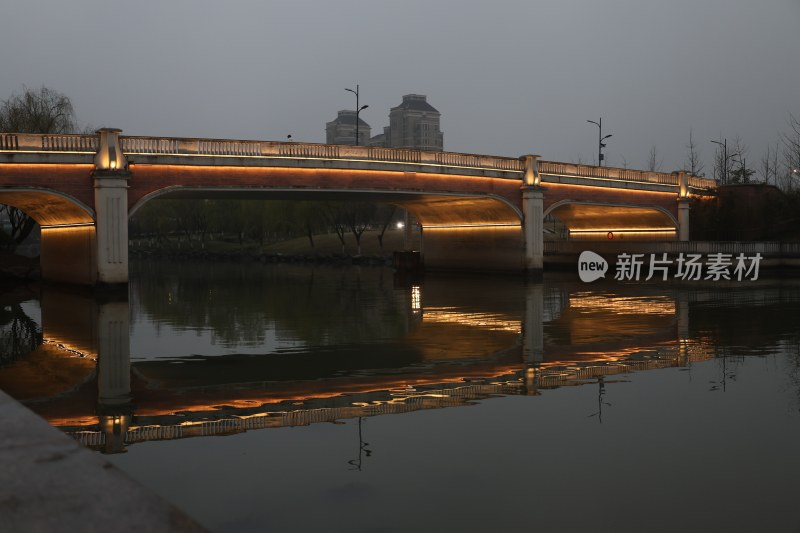 夜晚河畔带灯光的拱形桥