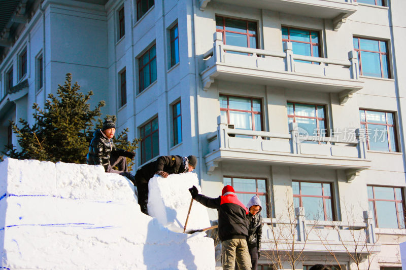 在哈尔滨人们户外合作制作大型雪雕