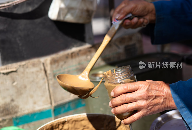 售卖芝麻酱的小贩在打芝麻酱