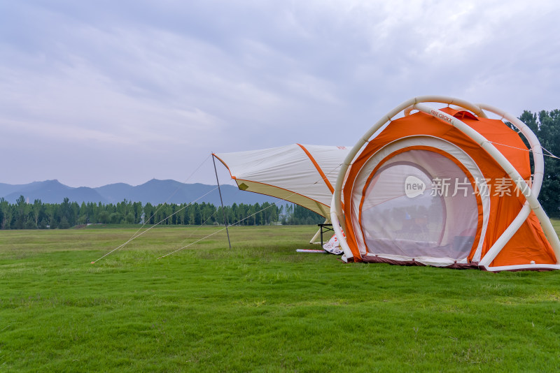 夏季绿色草坪上的户外露营帐篷