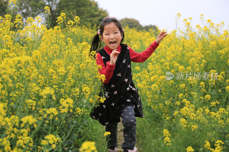 油菜花田里快乐奔跑的快乐女孩