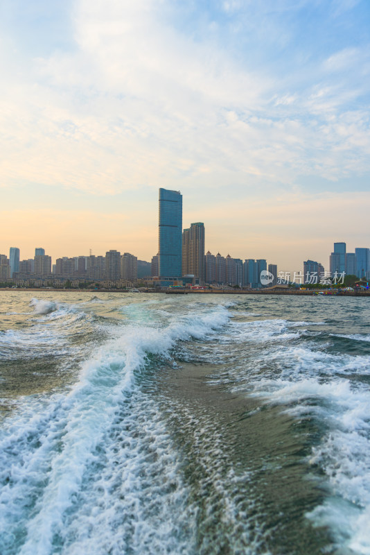 城市高楼背景下的海面快艇破浪前行