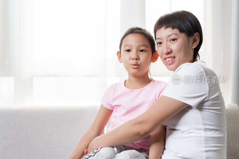 坐在沙发上亲密相拥的中国母女