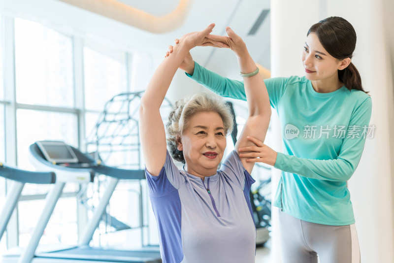 老年女子在私教的指导下健身