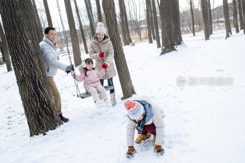 快乐的一家人在雪地里玩耍