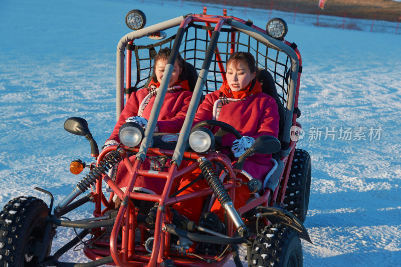 在冰天雪地玩耍雪上娱乐载具车辆的闺蜜少女