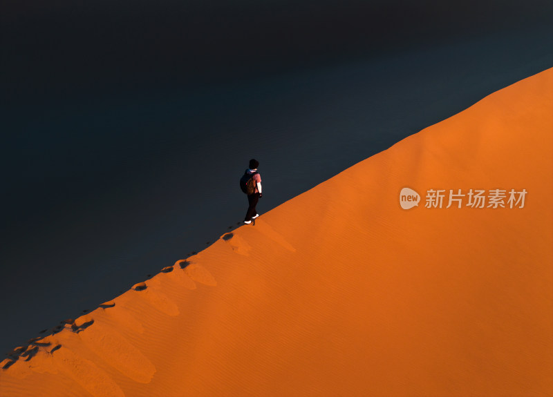 航拍男人站在新疆库木塔格沙漠的沙脊上