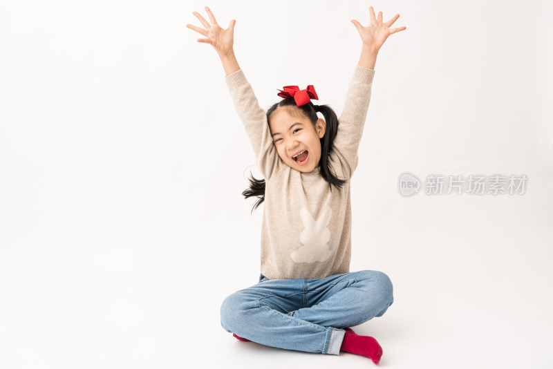 坐在白色背景前玩耍的中国女孩