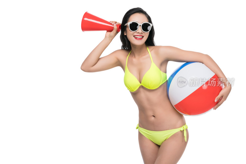泳装年轻女子拿着沙滩球和扬声器