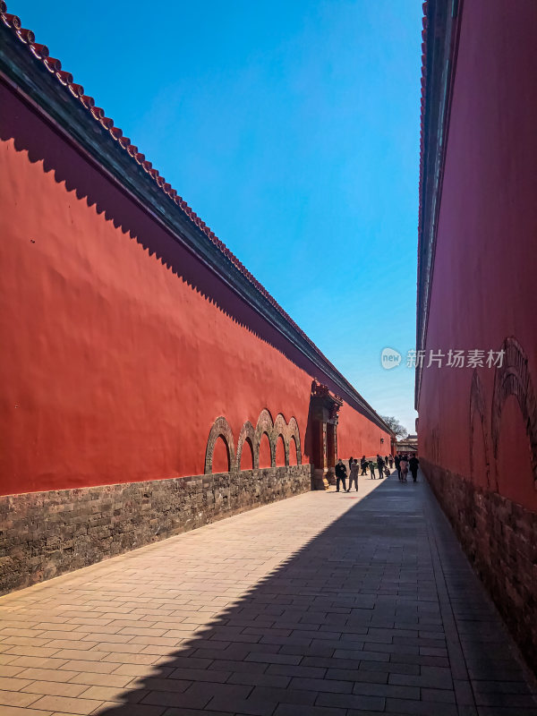 红墙古建筑间行人漫步