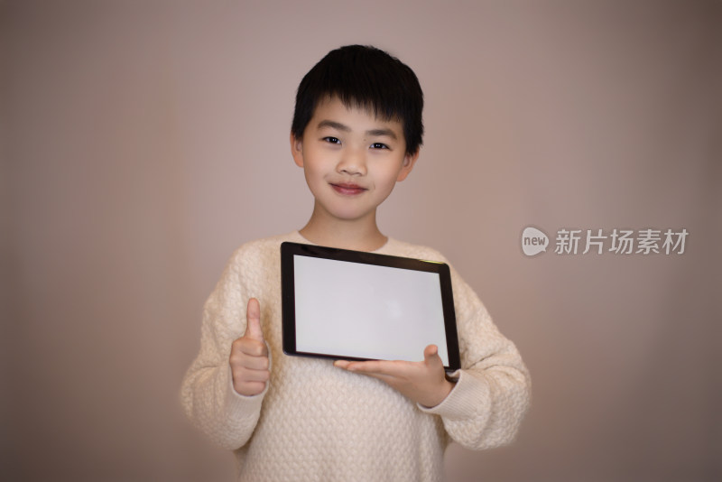 一个中国小男孩在展示平板电脑里的内容