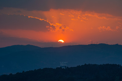 山间日落美景，太阳余晖洒满天际