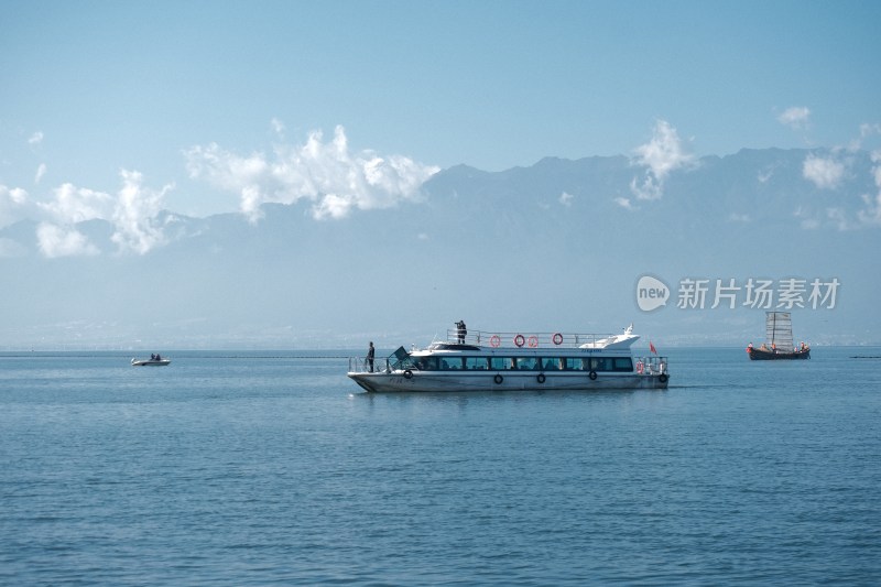 大理开海节湖上渔民驾木船作业场景