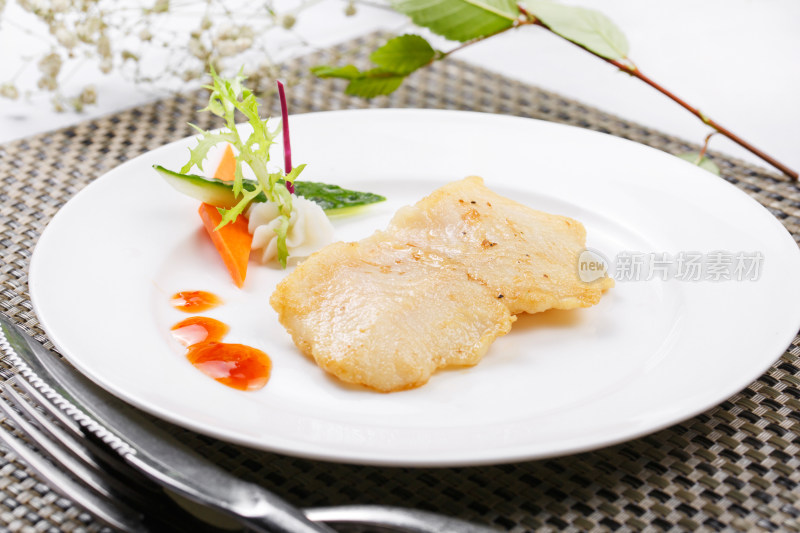 日式铁板煎石斑鱼摆放在餐垫上