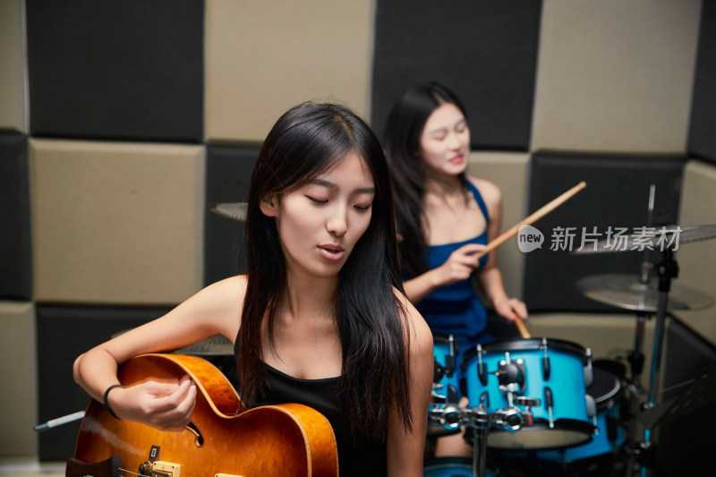 在录音室排练演奏的亚洲少女